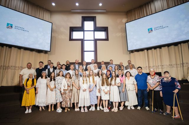 Учасники хрещення, служителі й церква — спільне фото в залі перед виїздом