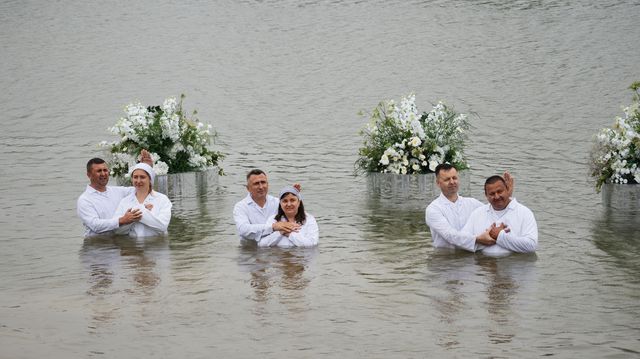 Хрещення трьох людей одночасно, на воді — білі квіти