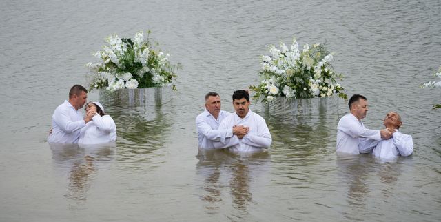 Три пари у воді на тлі білих квітів