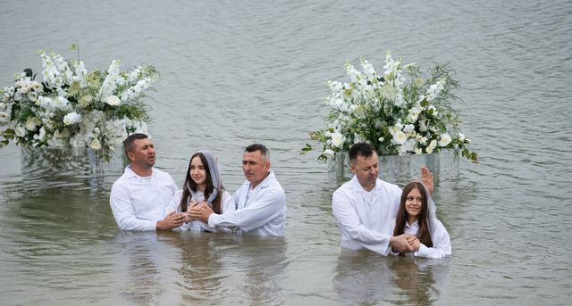 Дві пари у воді між квітковими композиціями