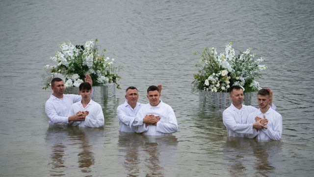 Три служителі й хрещені юнаки у воді