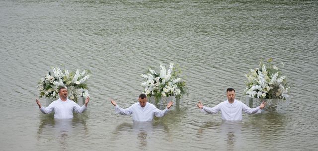 Служителі у воді з піднятими руками — молитва