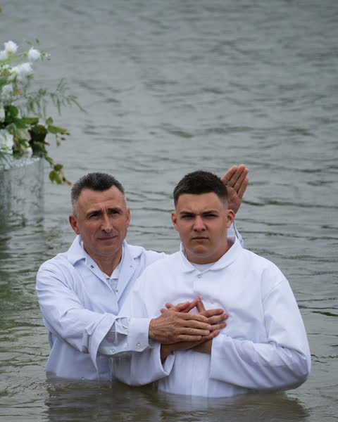 Водне хрещення: служитель і охрещений брат стоять у воді